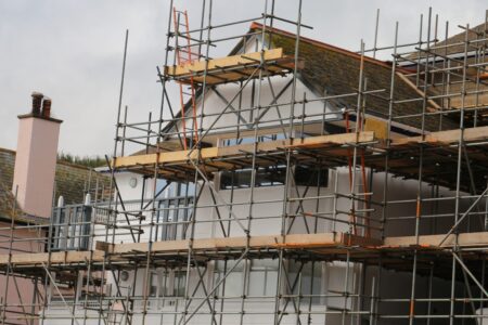 Common VAT mistakes with property renovations - a building with scaffolding over the front and a grey sky behind