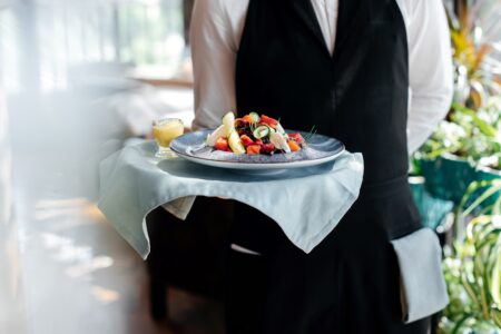 Allocation of Tips - A new regime. Waiter holding tray of food